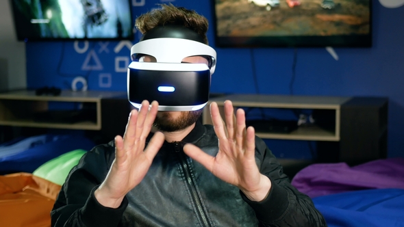 Bearded Guy Looks at His Hands Through Virtual Reality Glasses