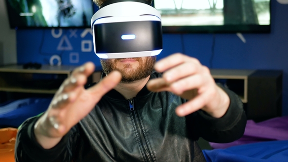 The Player Sees Virtual Reality for the First Time. A Young Man Grab Hold of Non-existent Objects.