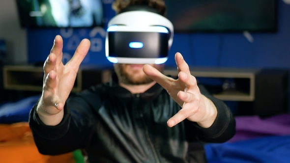 The Player Sees Virtual Reality for the First Time. A Young Man Grab Hold of Non-existent Objects.