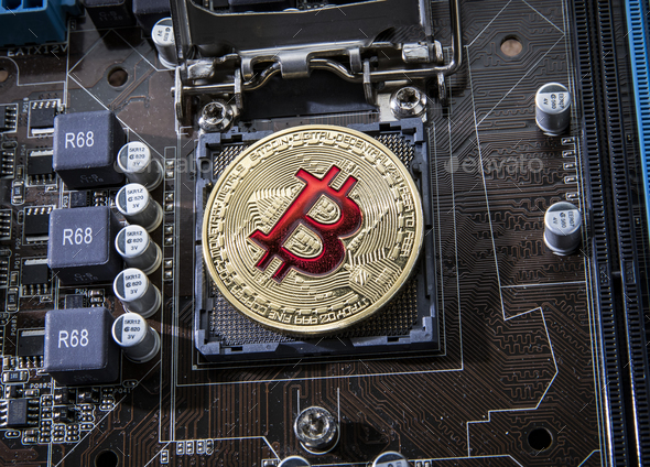 Gold Bit Coin BTC coins on the motherboard. Bitcoin is a worldwi - Stock Photo - Images