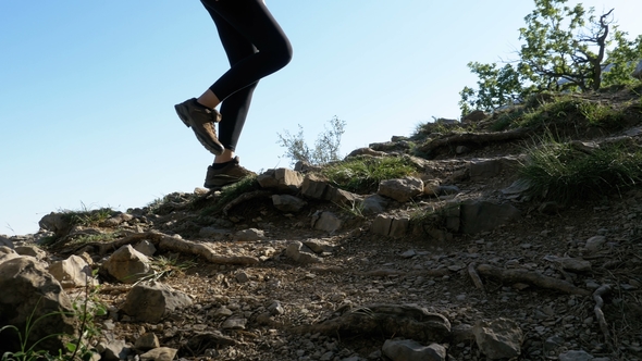 View on Feet of Traveler Woman Hiking Walking on the Top of Cliff in Mountain. Walking on Rocks alt