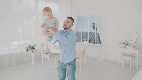 Father Swinging His Beautiful Daughter in the Room