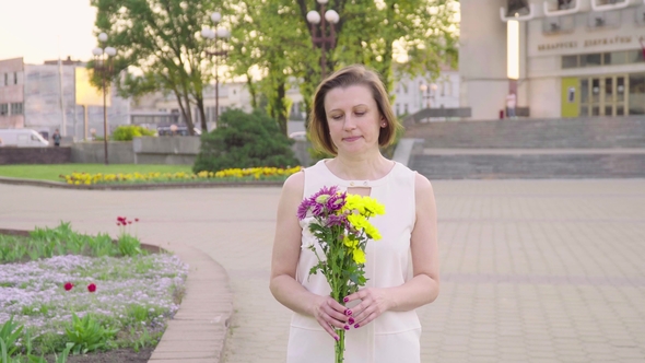 Beautiful Lady Holding a Bouquet of Beautiful Flowers. Female Hand Touching Beautiful Flowers