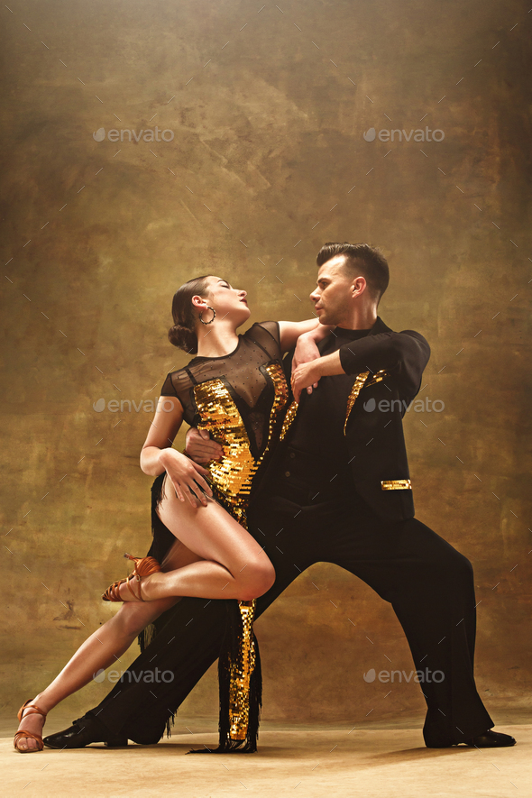 Dance ballroom couple in gold dress dancing on studio background. - Stock Photo - Images
