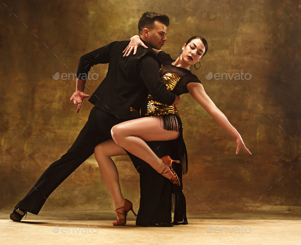 Dance ballroom couple in gold dress dancing on studio background. Stock Photo by master1305