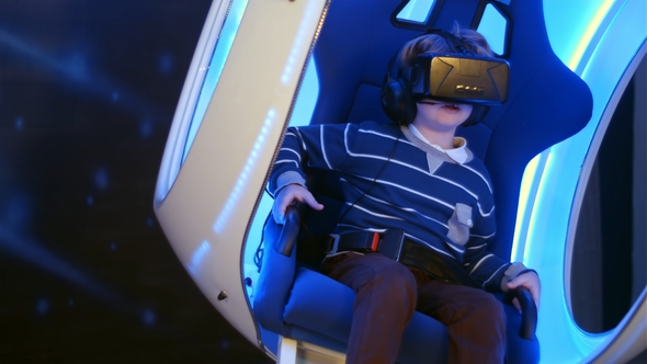 Little Boy Experiencing Virtual Reality Sitting in Interactive Moving Chair alt