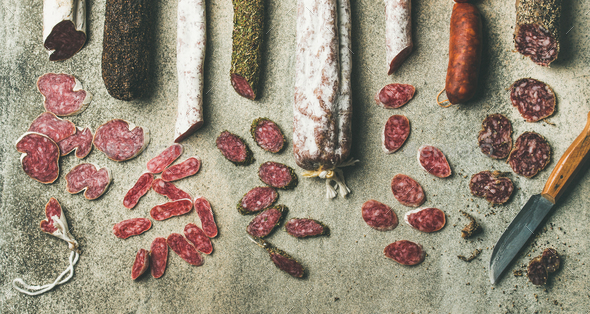 Spanish or Italian cured sausages in slices, wide composition - Stock Photo - Images