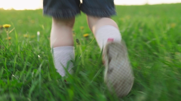 Child Runs on Green Grass in Summer Day