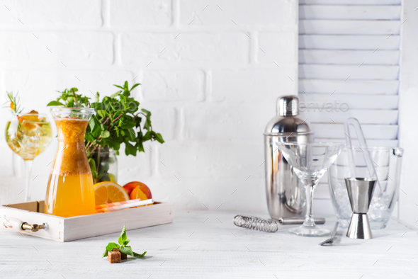 lemonade in the decanter on a wooden tray and Cocktail shaker for preparing a summer cocktail - Stock Photo - Images