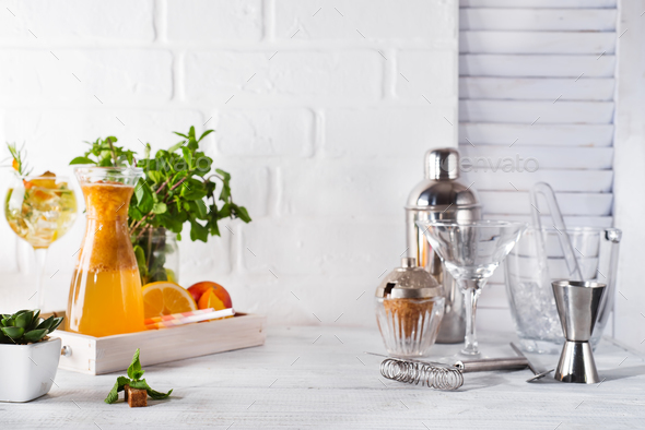 lemonade in the decanter on a wooden tray and Cocktail shaker for preparing a summer cocktail - Stock Photo - Images