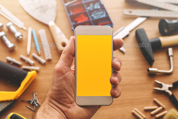 Repairman holding smart phone with blank screen in hand - Stock Photo - Images