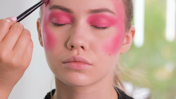 Fashion Model Getting Ready for Shooting. Makeup Artist Hands Apply Cosmetics on Model Face in a