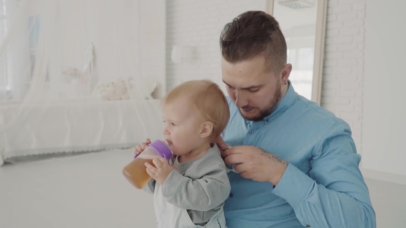 Farther Dresses His Beautiful Daughter on Knee. Happy Family.