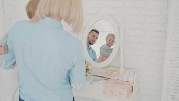 Mother and Her Little Baby Near the Mirror. Happy Family.