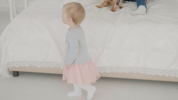 Mother Playing with Her Lovely Child Near the Bed. Happy Family.