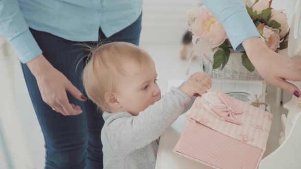 Mother and Her Little Baby Near the Mirror. Beautiful Girl Watching the Box. Happy Family