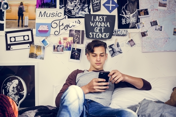 Teenage Boy Using Smartphone In A Bedroom Social Media Concept