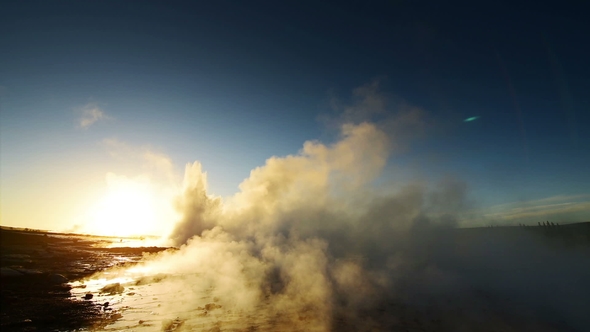 Eruption of Geyser in Iceland. Winter Cold Colors, Sun Lighting Through the Steam