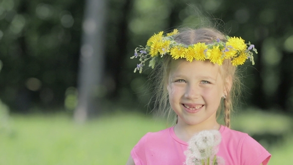 Portrait of a Funny Little Girl in the Woods. A Child Without Front Teeth Looks Into the Camera and alt