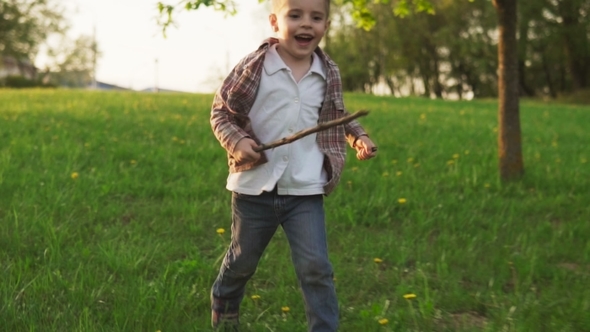 Happy Little Boy Running on Grass in Sunny Summer Park