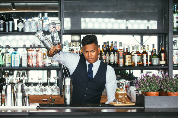 Expert bartender adds alcohol to a shaker - Stock Photo - Images