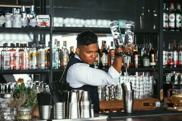 Expert barman adding alcohol to a shaker - Stock Photo - Images