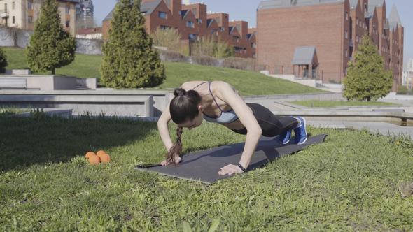 Woman Fitness Push-ups on the Grass in the Park