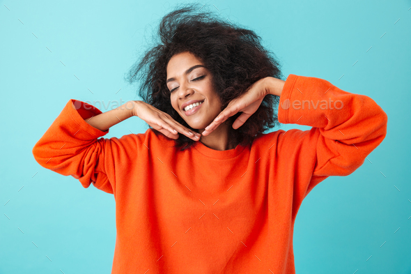 Young american woman in orange shirt posing on camera with lovel - Stock Photo - Images