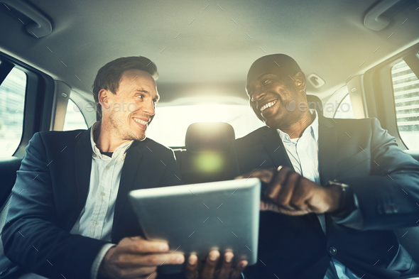 Business colleagues working online in the backseat of a car - Stock Photo - Images