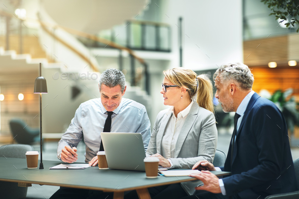 Mature work colleagues talking business together in an office - Stock Photo - Images