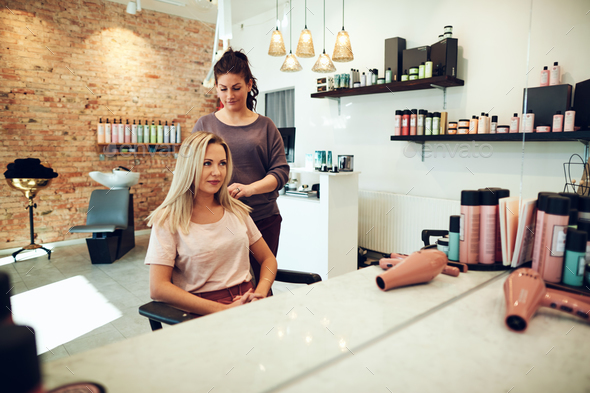 Smiling woman talking with her hairstylist in a salon - Stock Photo - Images
