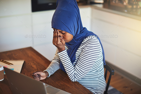Young Arabic female entrepreneur sitting at home looking stressed out - Stock Photo - Images