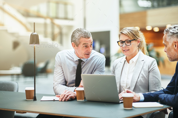 Mature businesspeople working at a table together in an office - Stock Photo - Images
