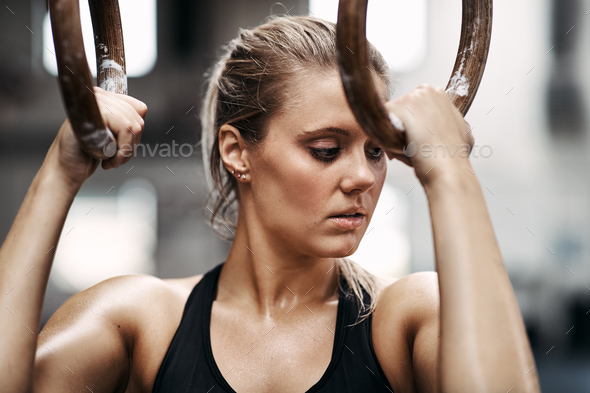 Focused young woman working out on rings at the gym - Stock Photo - Images