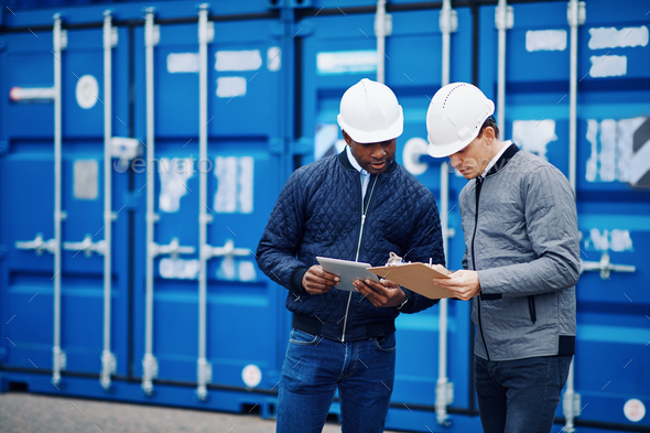 Two engineers tracking shipping containers in a freight yard - Stock Photo - Images
