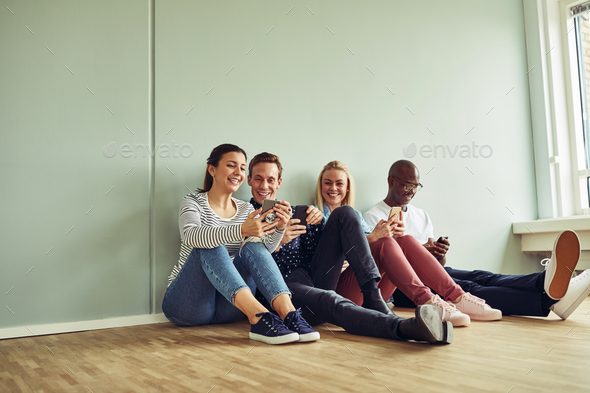 Young coworkers sitting on an office floor during a break - Stock Photo - Images