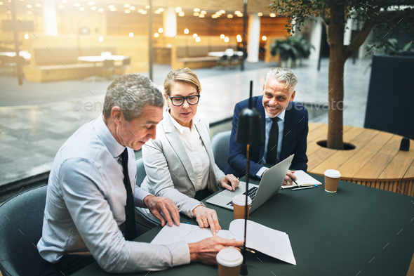 Mature businesspeople working in the lobby of an office building - Stock Photo - Images