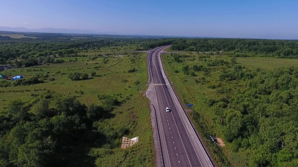 Aerial View Above Cars Driving Along Empty Countryside Road on Sunny Day alt