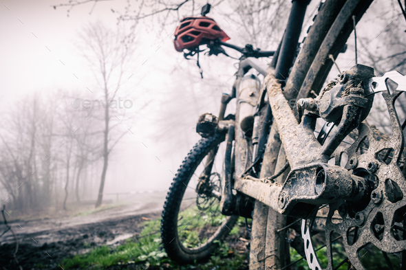 Mountain bike and helmet in autumn woods, dirty bicycle - Stock Photo - Images