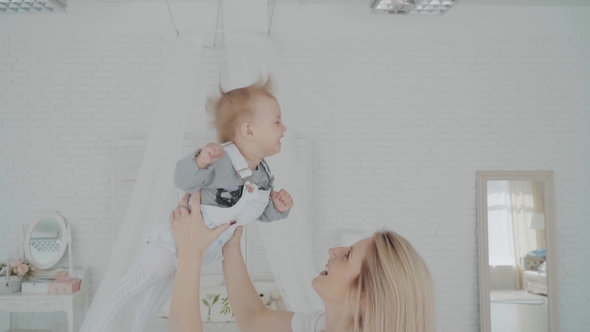 Mother Swinging Her Beautiful Daughter in the Room. Happy Family.