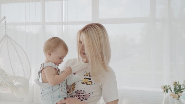 Mother Playing with Her Beautiful Daughter in the Room