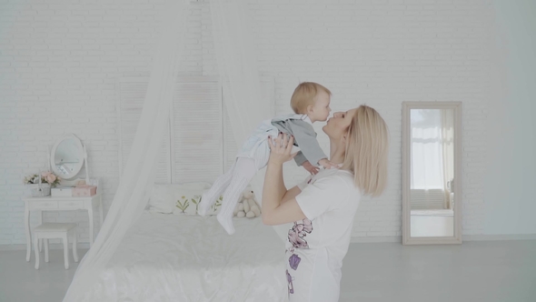 Mother Swinging Her Beautiful Daughter in the Room. Happy Family.