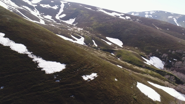 Flight over Mountain Slopes without Vegetation with Snow-covered Areas