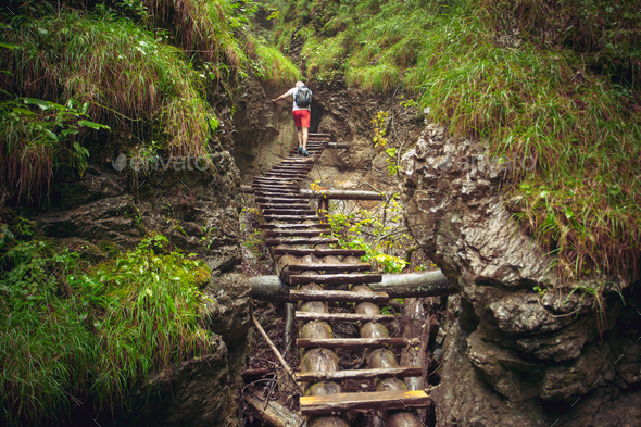 Hiker walking hard way through the canyon - Stock Photo - Images