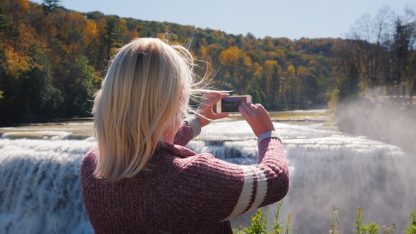 A Tourist Takes Pictures of a Beautiful Waterfall in Letchworth State Park alt