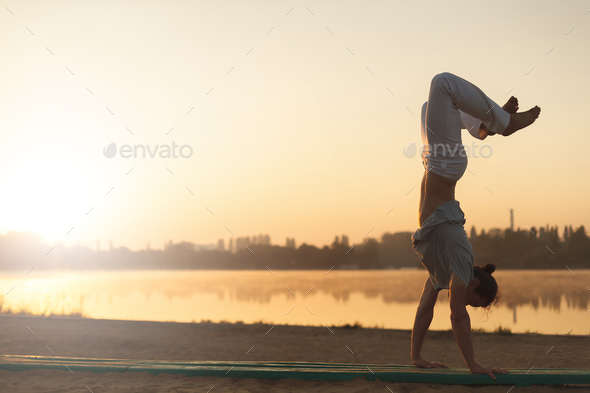 Athletic capoeira performer workout training on the beach sunris - Stock Photo - Images