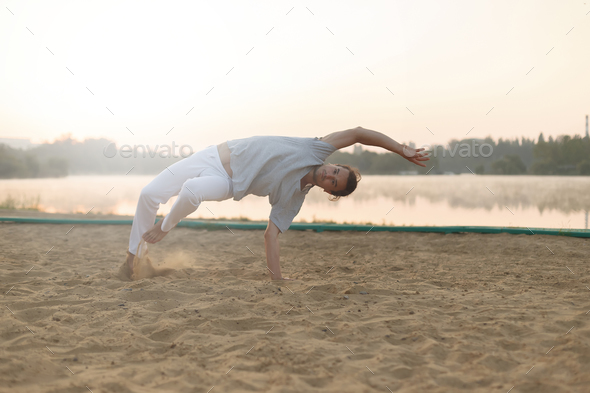 Athletic capoeira performer workout training on the beach sunris - Stock Photo - Images