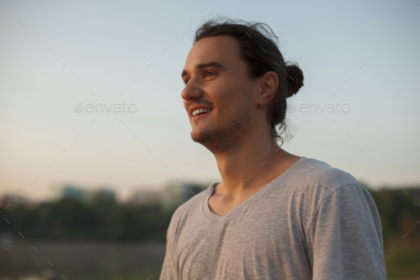Handsome man smiling in the park - Stock Photo - Images