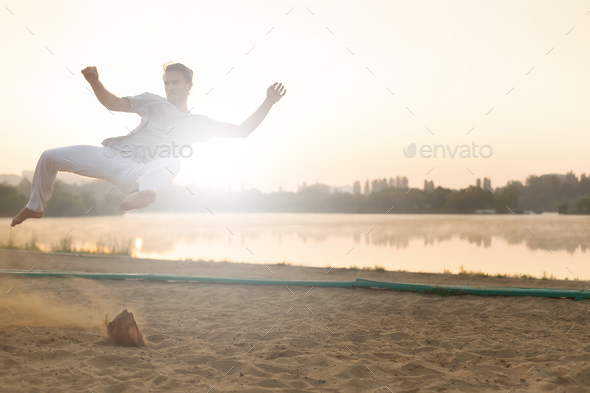 Athletic capoeira performer workout training on the beach sunris - Stock Photo - Images