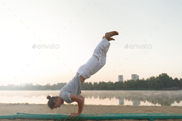 Young athletic man doing yoga poses near the lacke - Stock Photo - Images